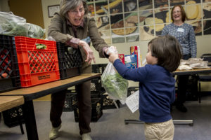 volunteer giving a child lettuce