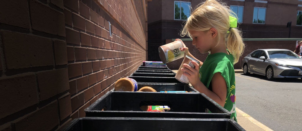 little girl donating to a food drive