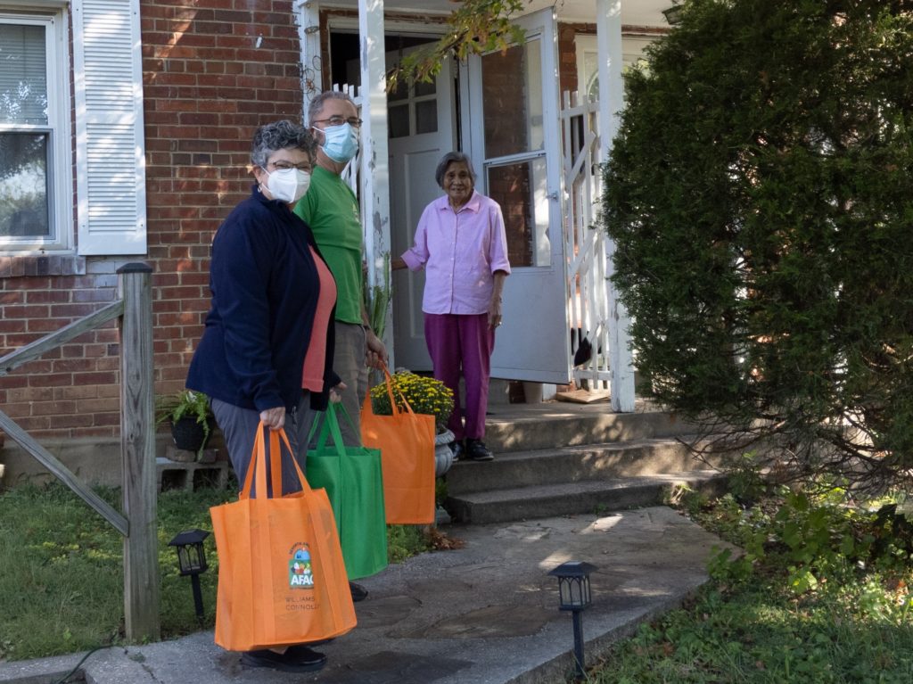 two volunteers delivering food to a clients' house