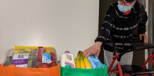 client reaching for grocery bags filled with food